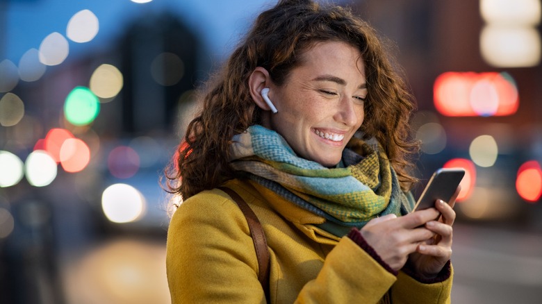 A girl with airpods holding a phone