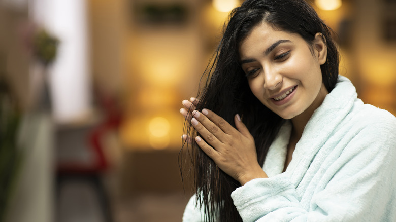 woman rubbing oil into hair