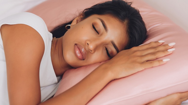 woman laying head on silk pillowcase.