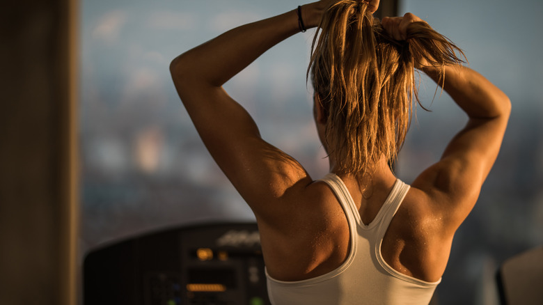 woman pulling hair up into ponytail