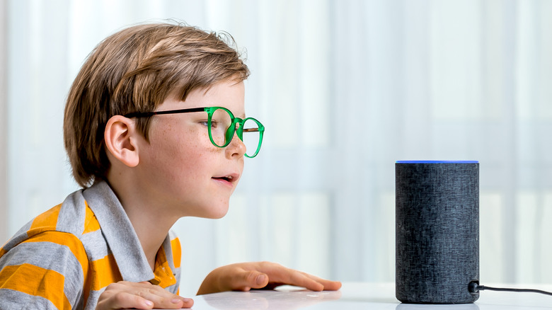 Young boy interacting with Alexa Amazon device