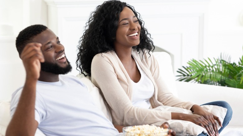 Black couple sitting on couch