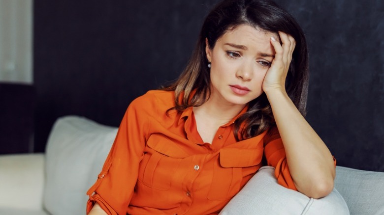 Woman looking upset on couch