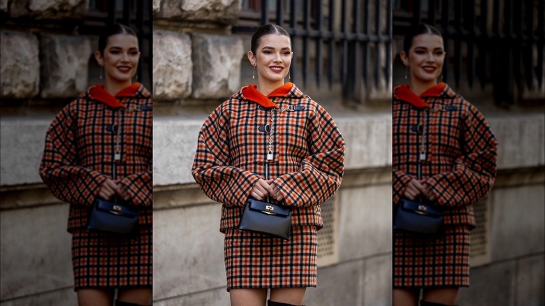 Woman wearing co-ord checkered coat and skirt