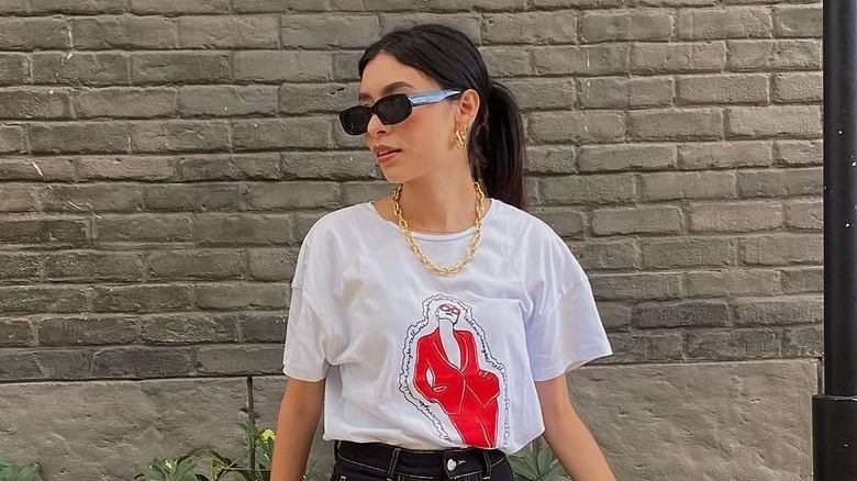 Woman wearing gold jewelry with a t-shirt.