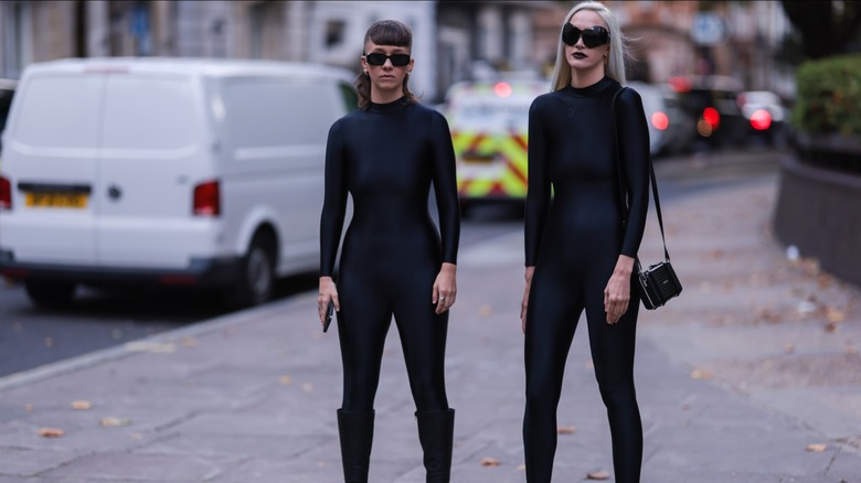 women wearing black nylon jumpsuits