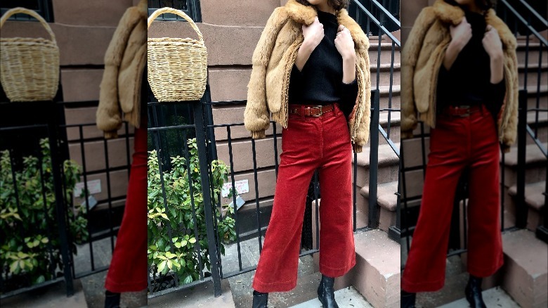 Girl in black top and red corduroy pants.