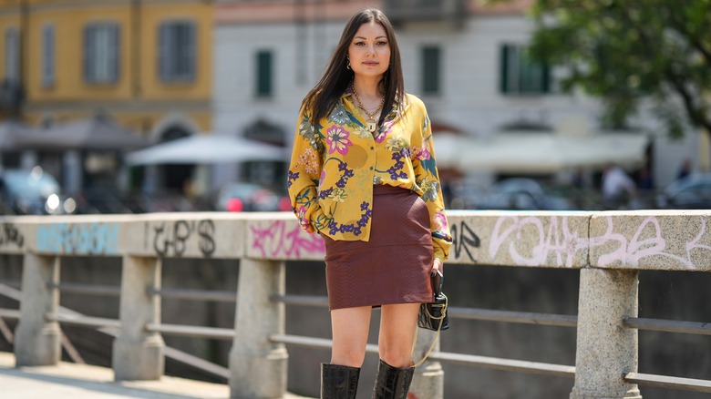Woman wearing floral blouse and leather skirt