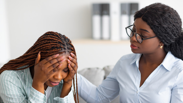 woman crying and being consoled