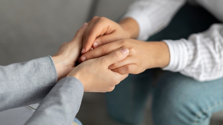 Woman holding hands in support