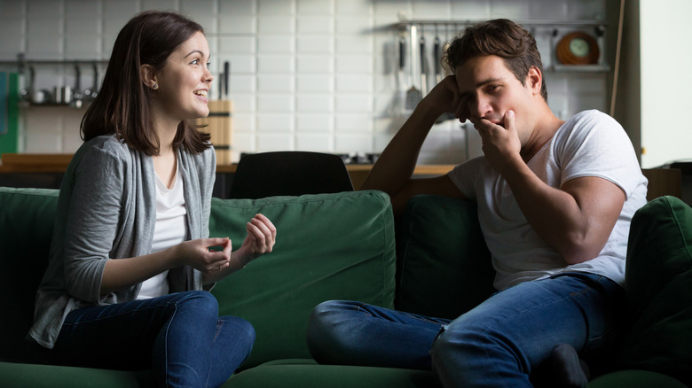 Man yawns while woman talks