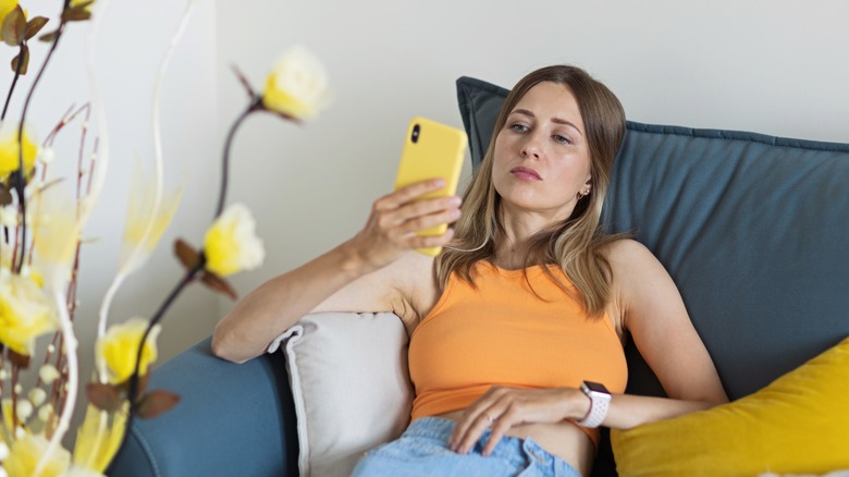 Unhappy woman looking at phone