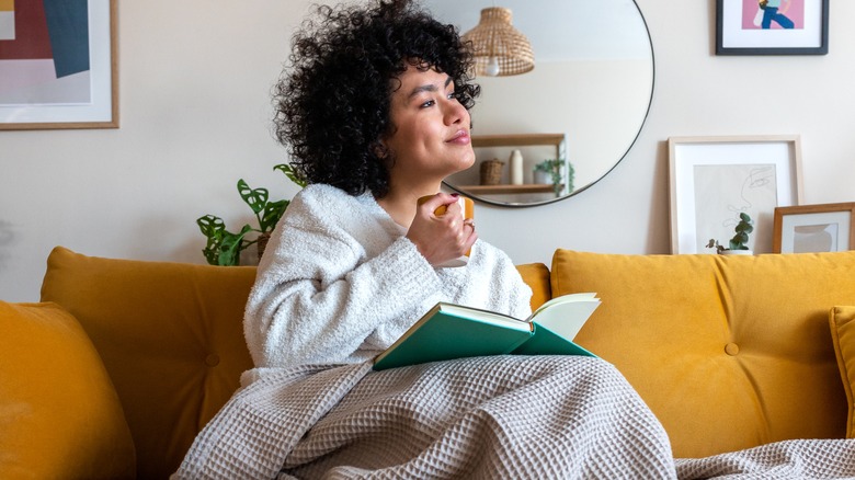 Smiling woman with book thinking