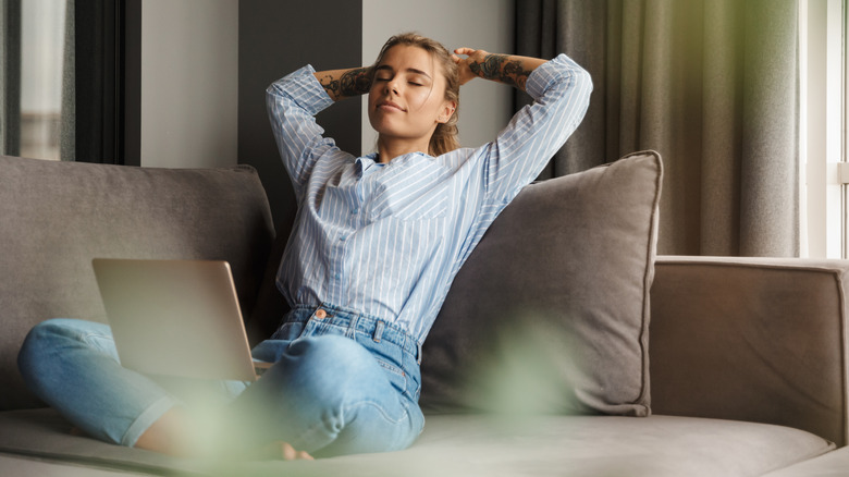 Woman with laptop on sofa