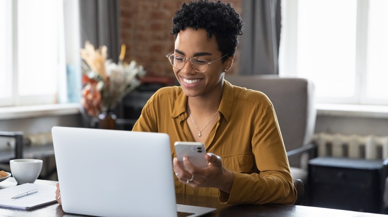 woman using laptop and phone