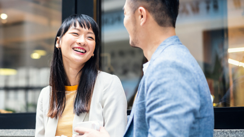 Man and woman smiling, talking