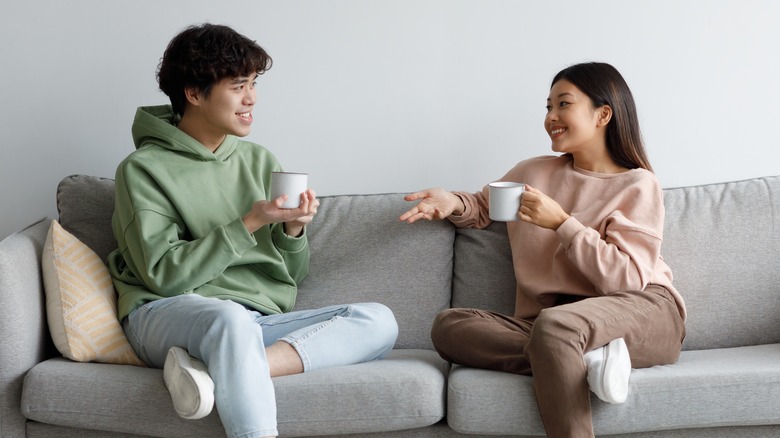 Asian couple chatting on sofa