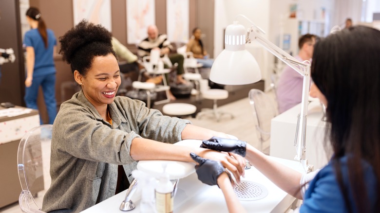 A woman getting her nails done at a nail salon.