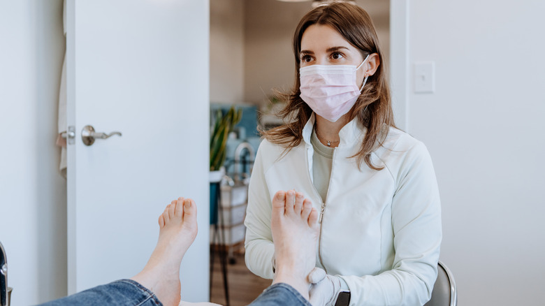 A toenail exam by a dermatologist.