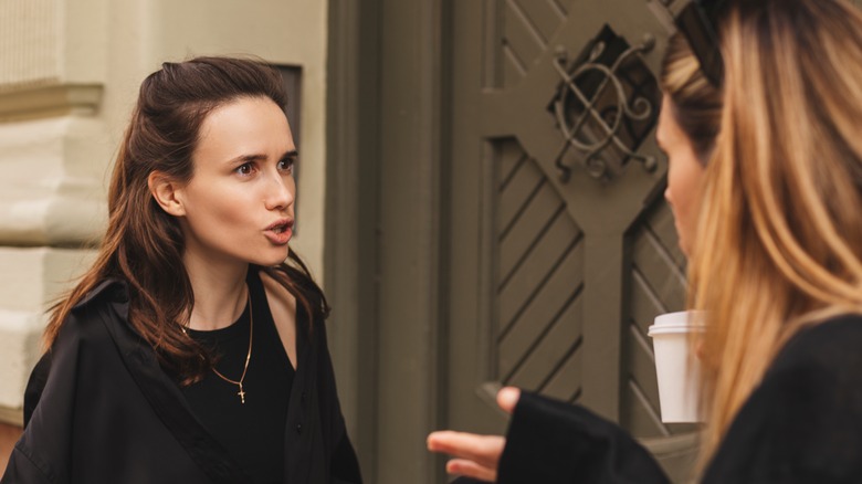 Sisters arguing outside on street