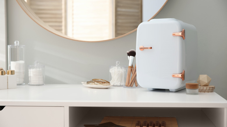 A makeup/skincare fridge on a vanity