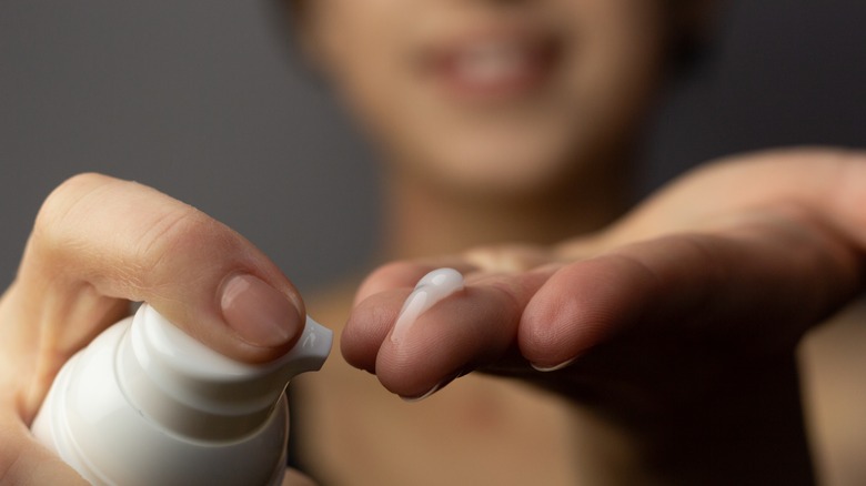 Person squeezing out topical cream.