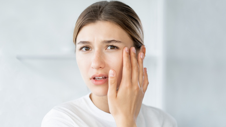 woman looking at eye in mirror