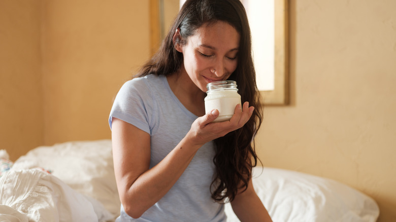 person happily smelling candle