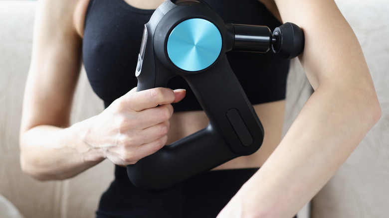 person using massage gun