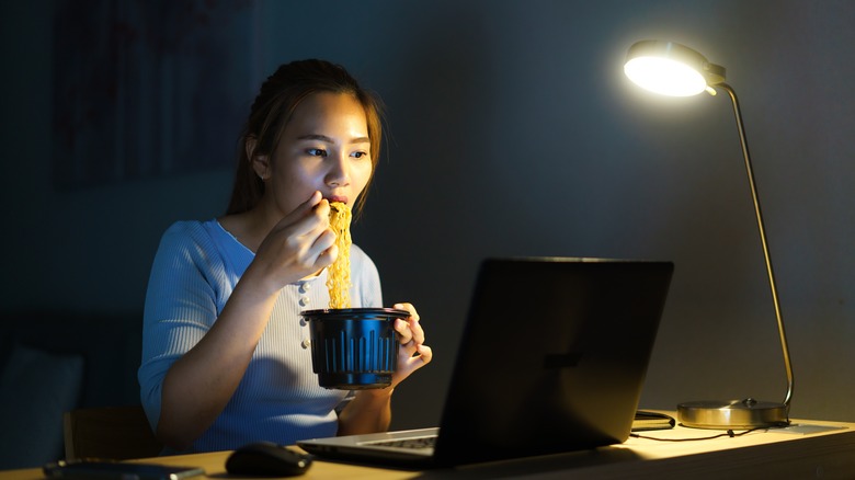 woman eating while working late