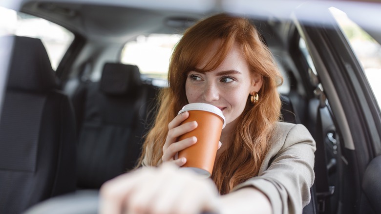 woman drinking coffee in car