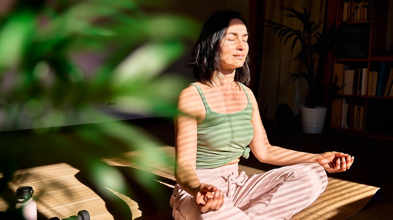 Woman meditates on yoga mat