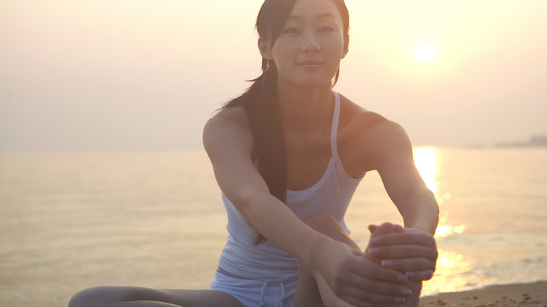 Woman stretches on beach