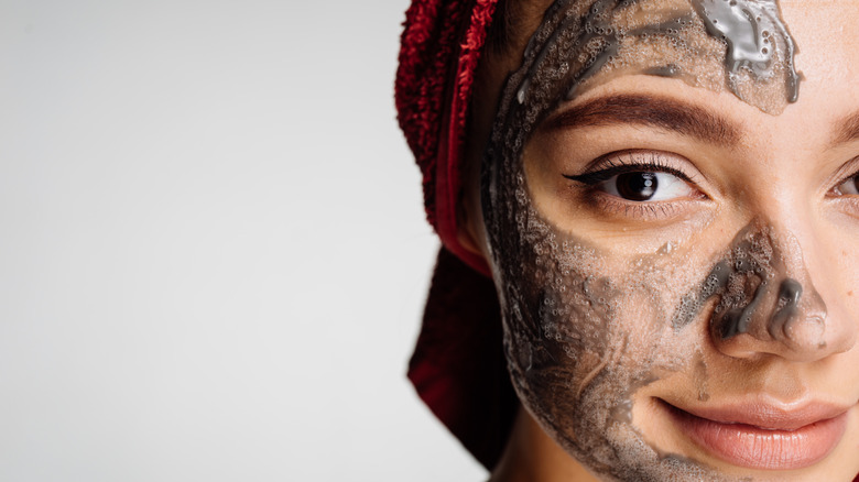 smiling woman using charcoal scrub