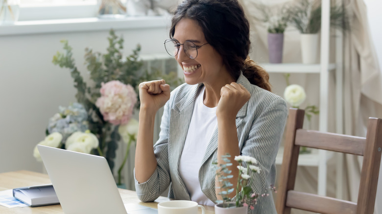 An excited woman looking at her computer