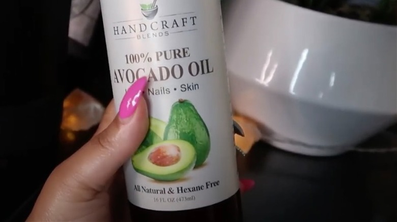 Woman holding avocado oil 