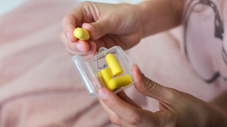 woman looking at earplugs