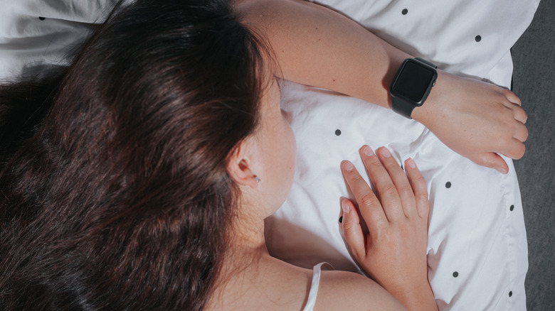 woman wearing smartwatch in bed