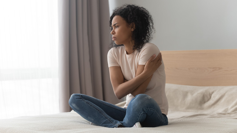 Upset woman sitting on bed