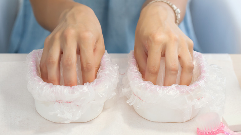 Woman soaking nails during manicure