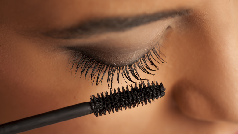 close up of woman applying mascara