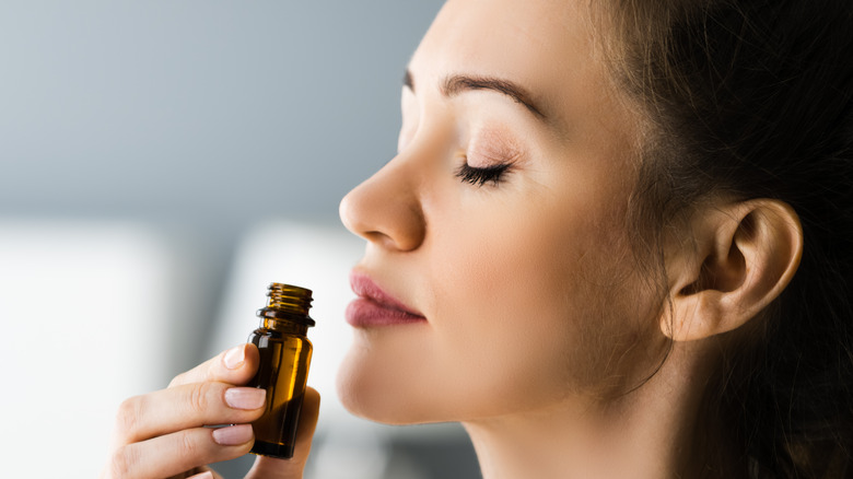 Woman sniffing essential oil 