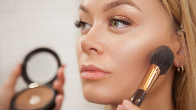 highlighter brush on woman's cheekbone