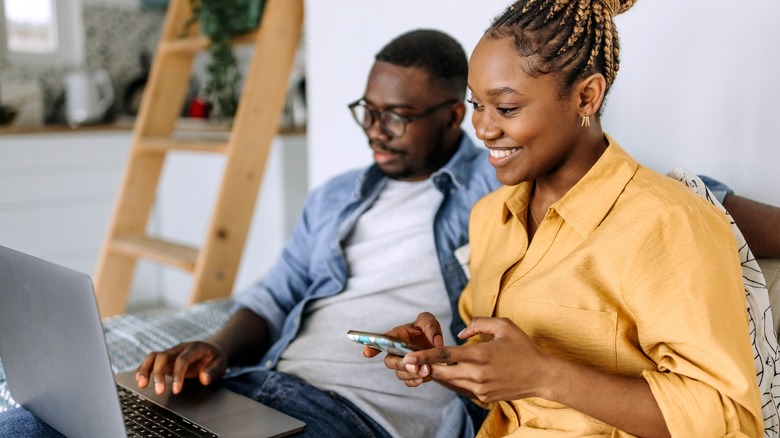 Happy couple looking at laptop