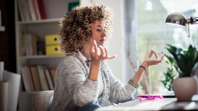 Woman meditating at her desk 