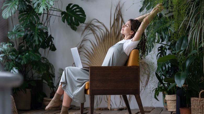 Woman stretching in a room of plants 