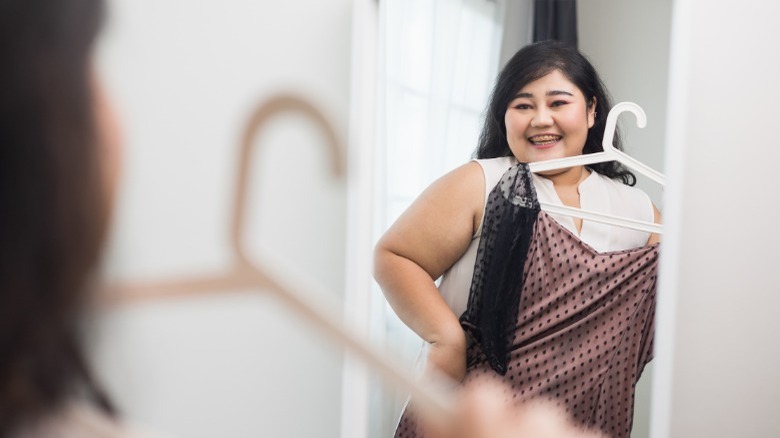 Plus size woman holding dress