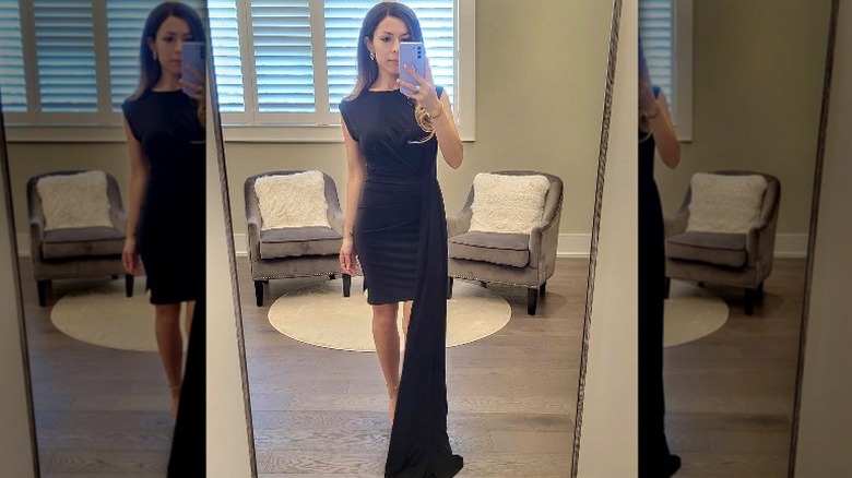 Instagram user showing black dress with side train in mirror selfie
