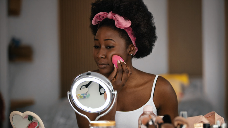 woman applying foundation