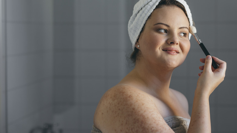 Woman smiling applying makeup